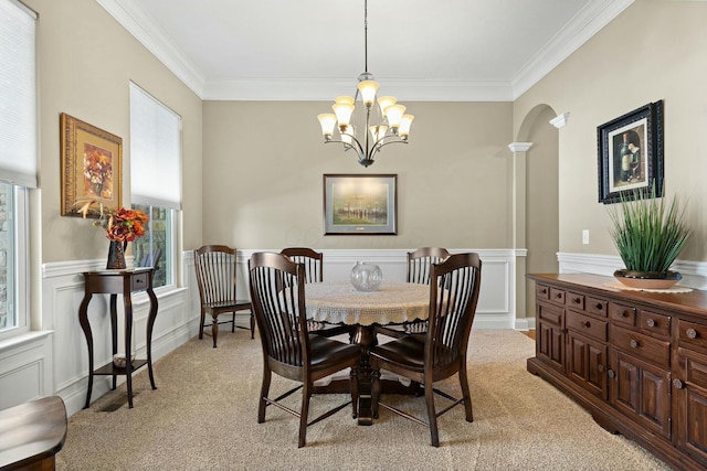 carpeted dining area featuring crown molding and a chandelier