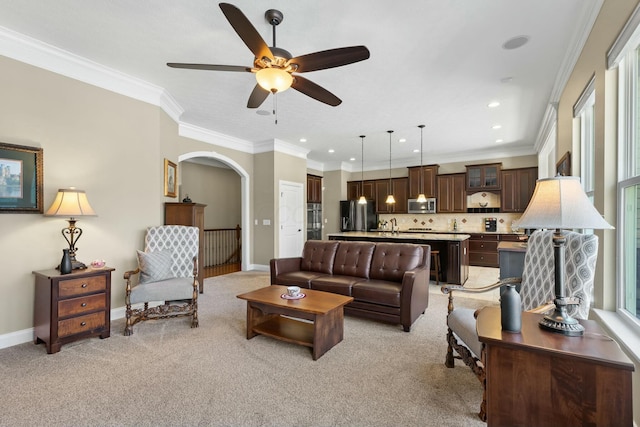 carpeted living room featuring crown molding and ceiling fan