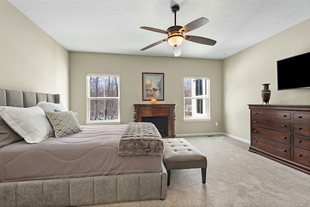 carpeted bedroom with ceiling fan and multiple windows