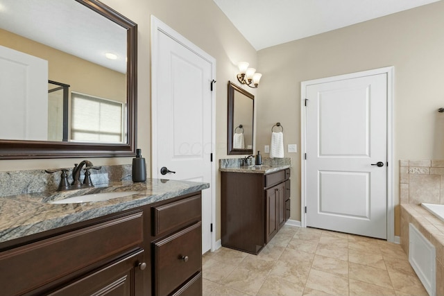 bathroom with tile patterned floors, vanity, and tiled tub