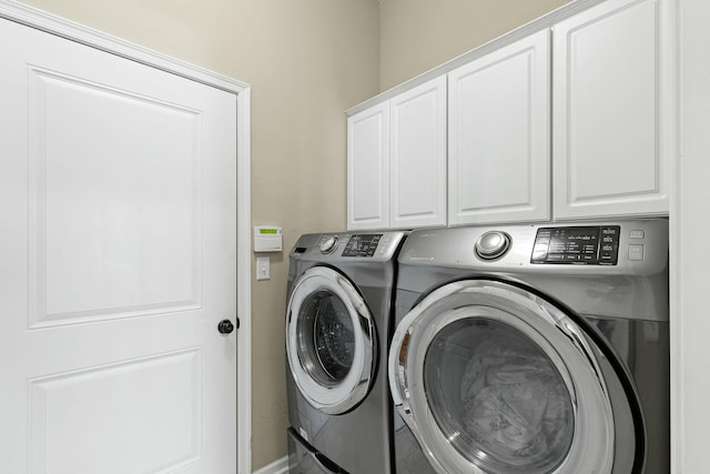 laundry room featuring washing machine and dryer and cabinets