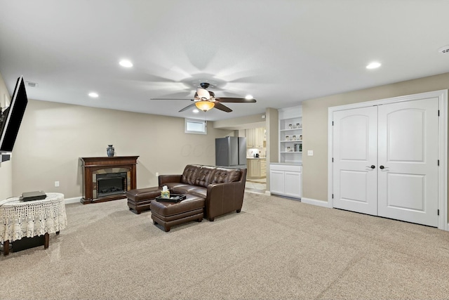 carpeted living room featuring ceiling fan and a fireplace