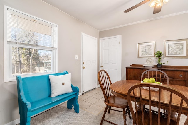 dining space featuring crown molding, light tile patterned floors, and ceiling fan