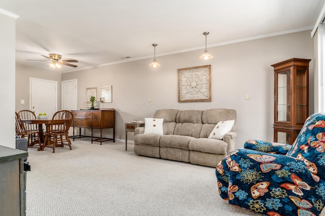 carpeted living room with ceiling fan and ornamental molding