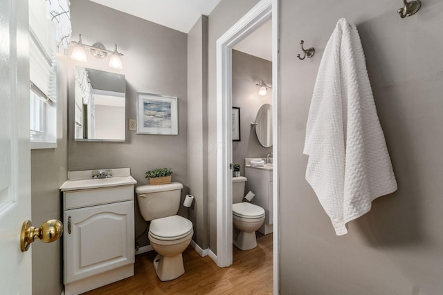 bathroom featuring wood-type flooring, toilet, and vanity