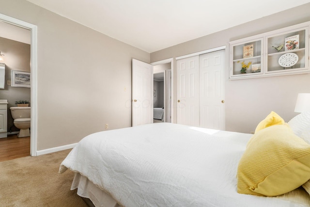 carpeted bedroom featuring ensuite bathroom and a closet