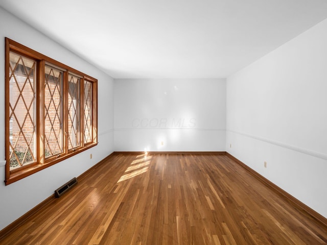 spare room with dark hardwood / wood-style flooring