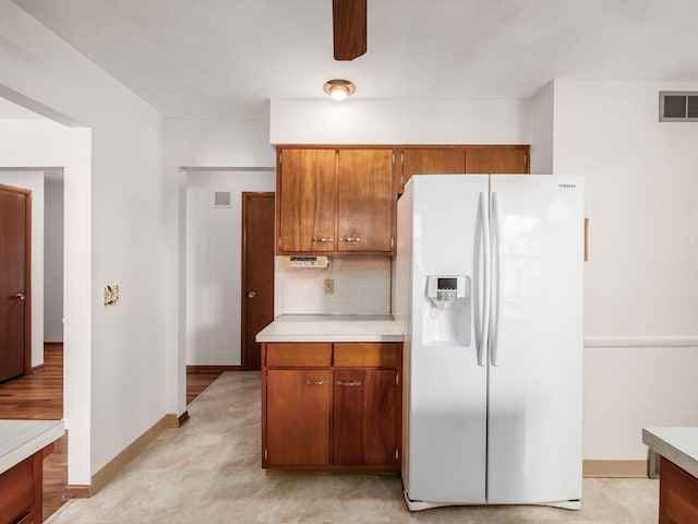 kitchen with tasteful backsplash and white fridge with ice dispenser