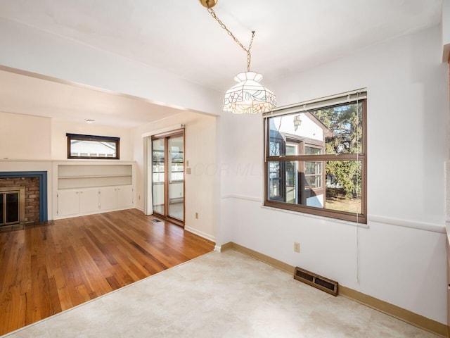 interior space with hardwood / wood-style floors, built in features, and a fireplace