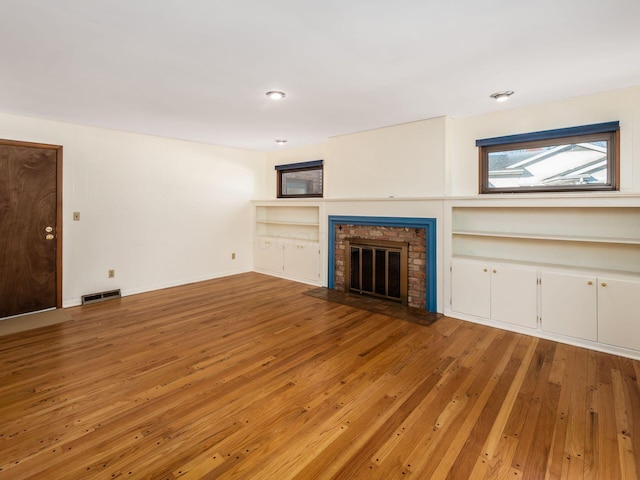 unfurnished living room with hardwood / wood-style floors and a fireplace