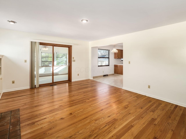 empty room featuring a baseboard radiator and light wood-type flooring