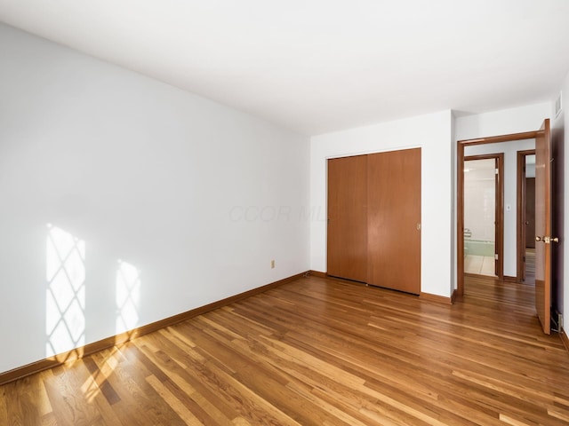 unfurnished bedroom with hardwood / wood-style flooring and a closet