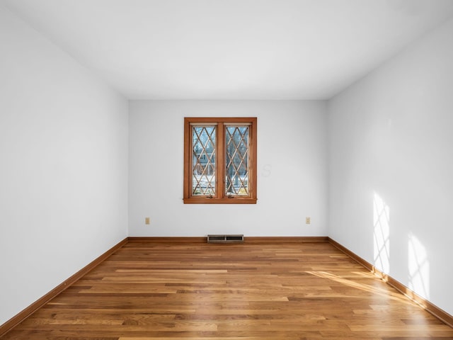 unfurnished room with hardwood / wood-style floors