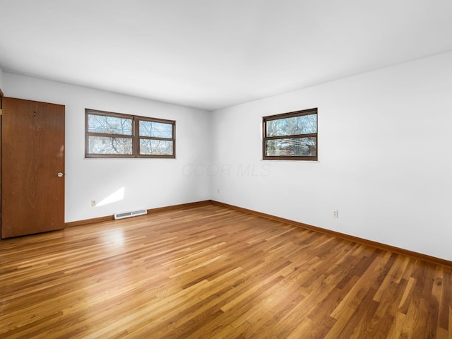 unfurnished room with a wealth of natural light and light hardwood / wood-style flooring