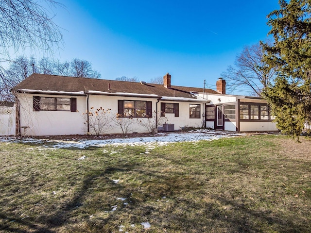 back of property featuring central AC, a sunroom, and a lawn