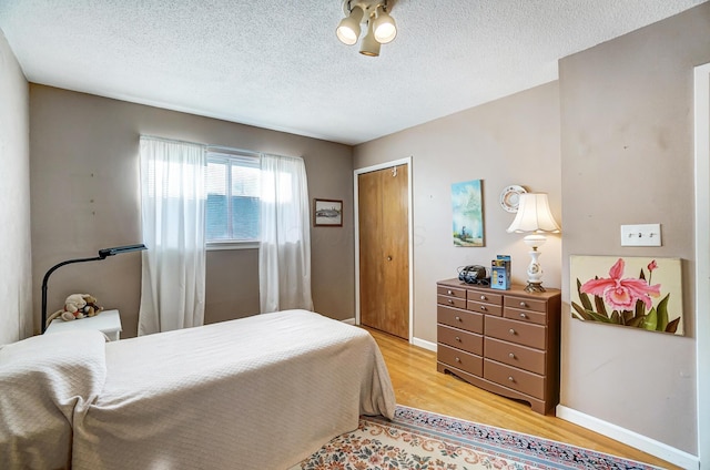 bedroom featuring hardwood / wood-style floors, a closet, and a textured ceiling