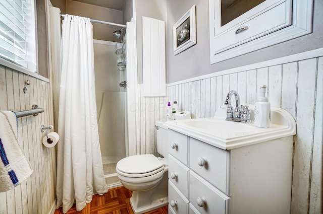 bathroom with parquet flooring, wooden walls, vanity, walk in shower, and toilet