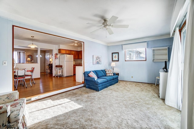 carpeted living room with ceiling fan