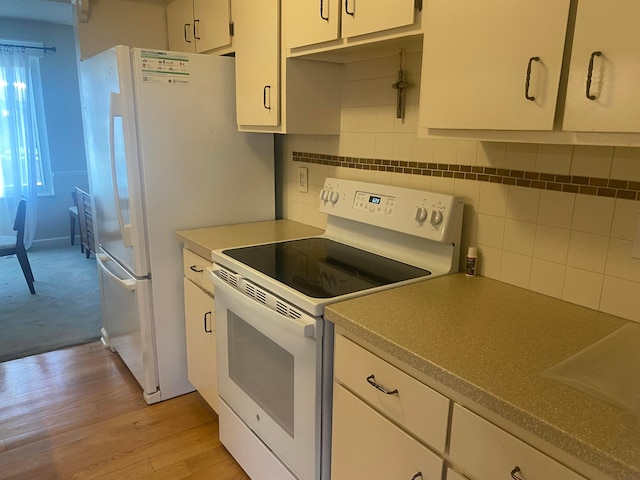 kitchen featuring backsplash, white cabinets, white electric range oven, and light wood-type flooring