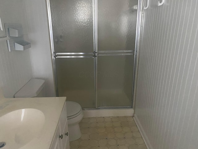 bathroom with toilet, vanity, and walk in shower