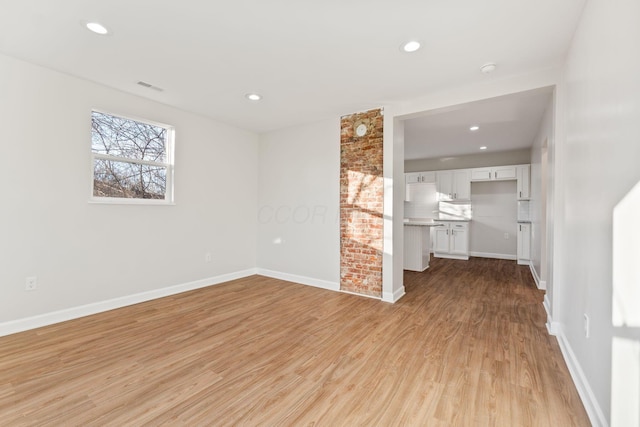 unfurnished living room featuring light wood-style flooring, baseboards, and recessed lighting