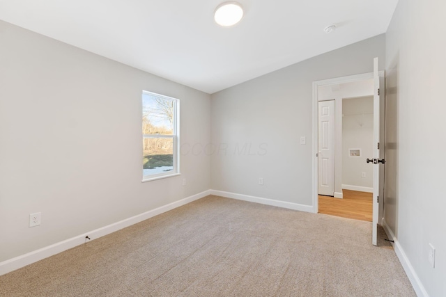 unfurnished room with light carpet and baseboards