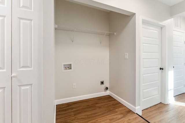 laundry area featuring light wood-style floors, baseboards, laundry area, and electric dryer hookup