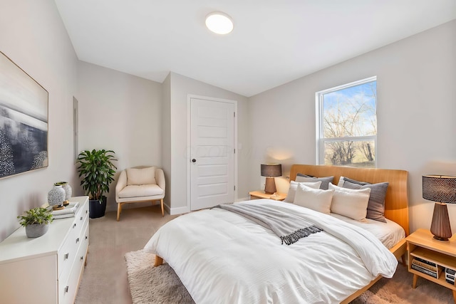 bedroom featuring vaulted ceiling and light colored carpet