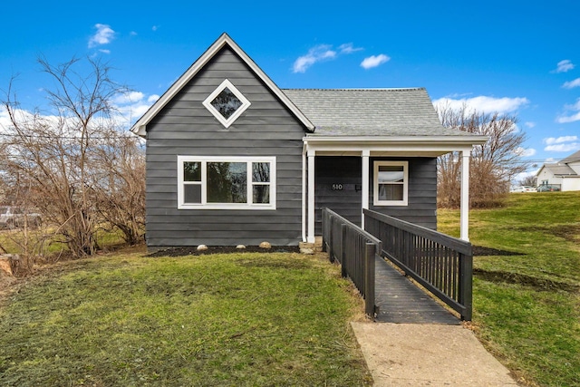 bungalow-style house featuring a shingled roof and a front yard