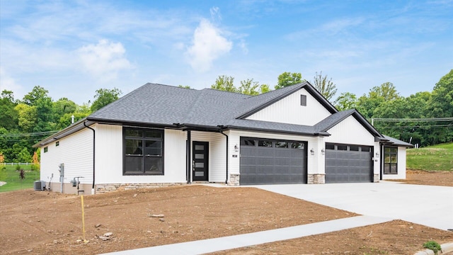 view of front facade featuring central AC unit and a garage