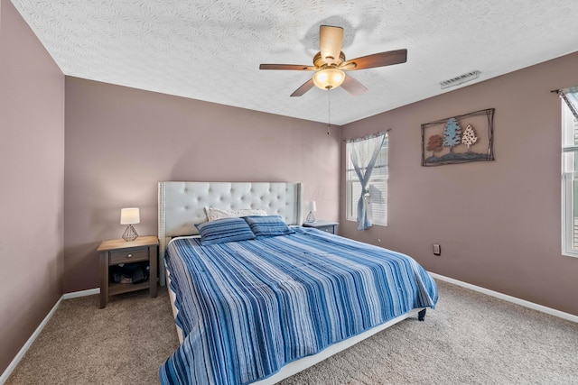 carpeted bedroom with a textured ceiling and ceiling fan