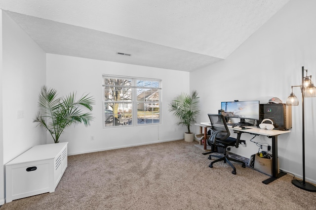 office area with vaulted ceiling, light colored carpet, and a textured ceiling