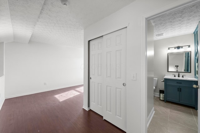 hall featuring sink and vaulted ceiling