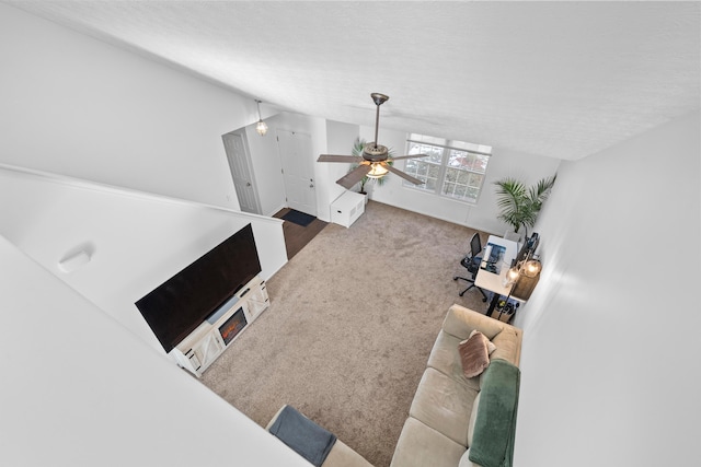 carpeted living room featuring a textured ceiling and ceiling fan