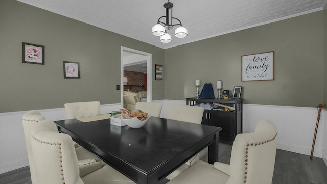 dining space with an inviting chandelier, crown molding, dark hardwood / wood-style floors, and a textured ceiling