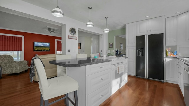 kitchen with white cabinetry, a center island, a kitchen breakfast bar, and black fridge with ice dispenser