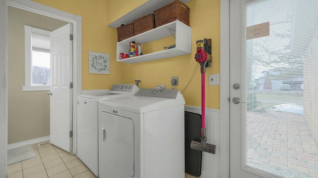 clothes washing area with separate washer and dryer and light tile patterned floors