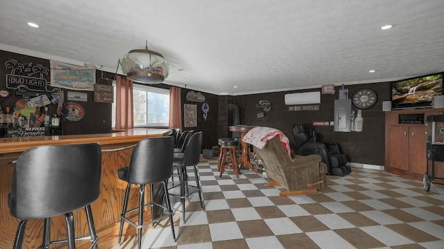 interior space with crown molding, a wall mounted air conditioner, electric panel, and a textured ceiling