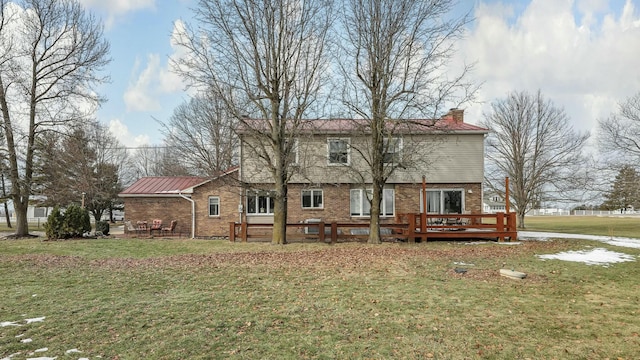 back of property featuring a wooden deck and a yard