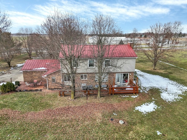 rear view of property featuring a lawn and a deck