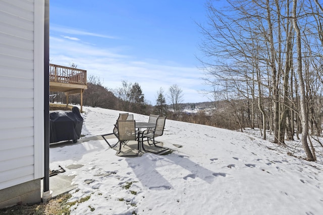 yard layered in snow with a deck