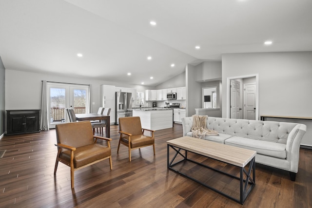 living room with dark hardwood / wood-style flooring, lofted ceiling, and french doors