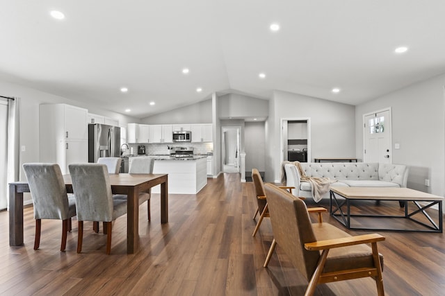 dining area featuring dark hardwood / wood-style flooring and vaulted ceiling