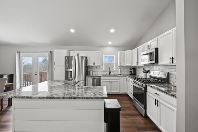 kitchen featuring sink, tasteful backsplash, a kitchen island, stainless steel appliances, and white cabinets