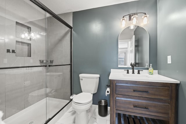 bathroom with vanity, toilet, and a shower with shower door