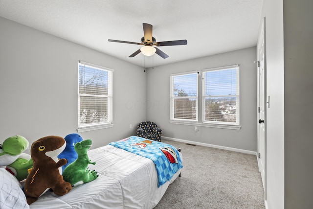 carpeted bedroom featuring multiple windows and ceiling fan