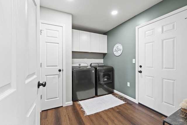 laundry area with cabinets, dark hardwood / wood-style flooring, and washer and clothes dryer