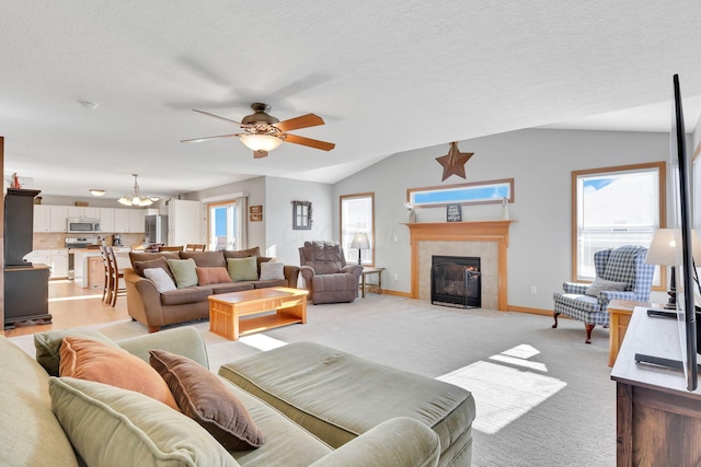 living room with light carpet, vaulted ceiling, a tile fireplace, and a textured ceiling