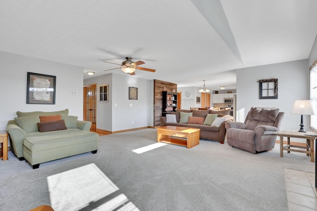 carpeted living room with ceiling fan with notable chandelier