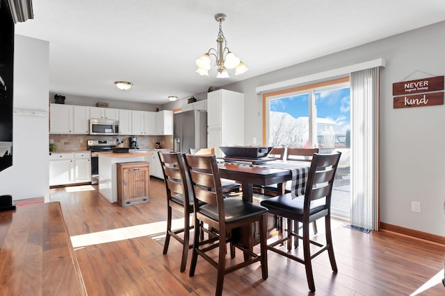 dining room with an inviting chandelier and light hardwood / wood-style floors